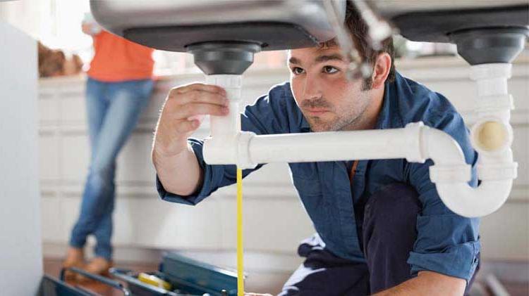 Landlord performing some plumbing repairs at a tenant's apartment.